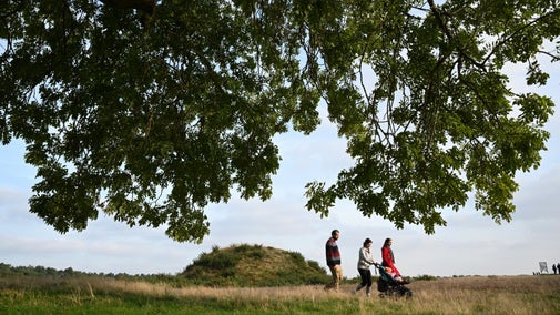 Visitors walking by the royal burial ground at Sutton Hoo